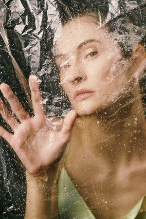 An attractive woman with plastic draped over her.の写真素材