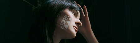 Woman with painted face poses by swamp.