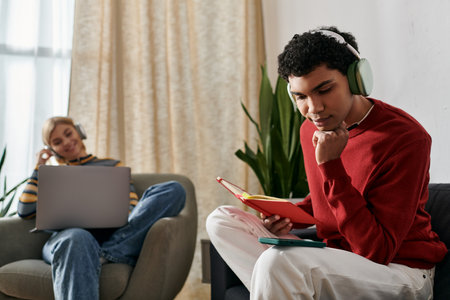 Multicultural couple relax at home in modern apartment. Man reads with headphones, woman works on...