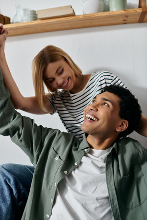 A young couple enjoys a moment of laughter and connection in their modern apartment.の写真素材