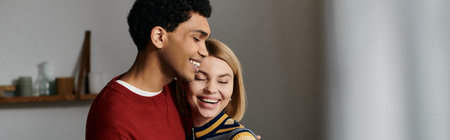 A happy interracial couple enjoys a moment of intimacy and laughter in their cozy apartment.