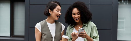 Two women, a lesbian couple, laugh together on a break outside their office building.