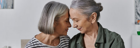 A mature lesbian couple shares a tender moment in their modern apartment.の写真素材