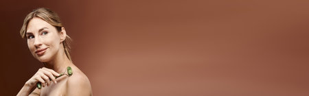 A young woman with vitiligo holds a jade roller against her skin, demonstrating a beauty routine.の写真素材