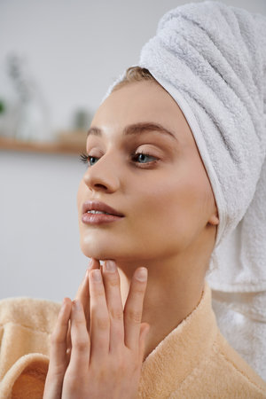 A young woman, wrapped in a towel, relaxes at home.の写真素材