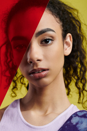 A young African American woman poses in a studio, bathed in lightの写真素材
