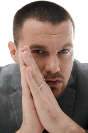 Man with stylish haircut, ring, chin on hands, looks thoughtful.の写真素材