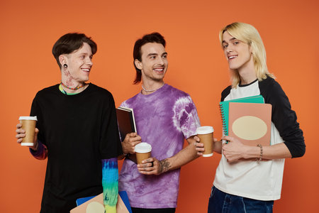 Three young friends in vibrant attire stand together on an orange background, enjoying coffee and...