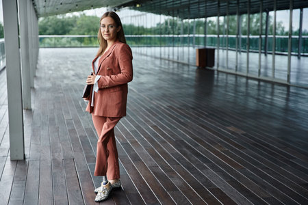 A woman in a pink suit, with prosthetic leg standing confidently on a rooftop terraceの写真素材