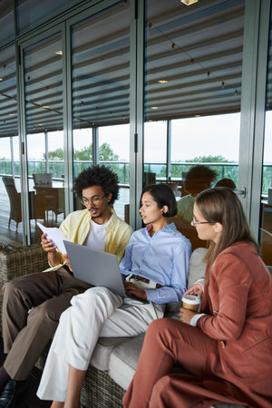 Colleagues have a relaxed chat on a rooftop terrace, emphasizing workplace diversity