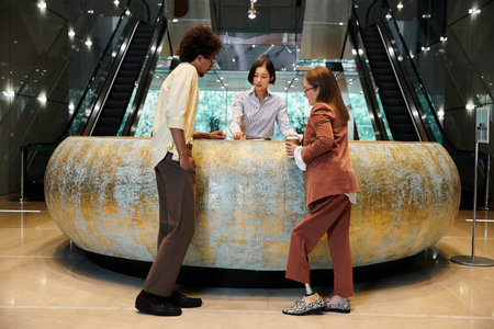 Three colleagues, including a woman with a prosthetic leg, chat and laugh together at a reception...