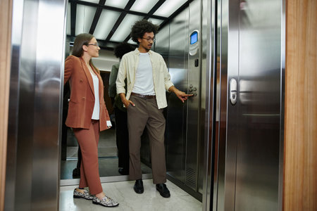Two colleagues, one with a prosthetic leg, chat in an elevator, waiting for their floor.