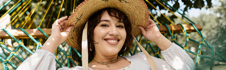 A brunette woman in a white dress and straw hat smiles while relaxing in a hammock on a summer day.