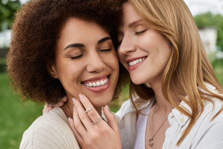 Two women smile and embrace while enjoying the sunshine.の写真素材