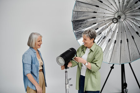 A mature lesbian couple enjoys a professional photography session in a studio.の写真素材