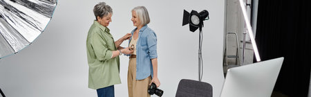 Two women, one a photographer and the other a model, work together in a studio setting.の写真素材