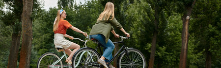 A lesbian couple enjoys a leisurely bike ride through a verdant park.の写真素材