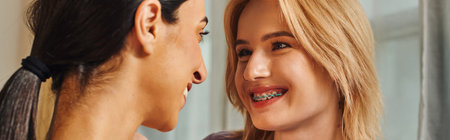 Two women embrace each other in their home, smiling brightly.の写真素材