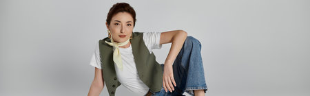 An Asian woman in a green vest and white t-shirt poses with a relaxed and stylish look, wearing a...