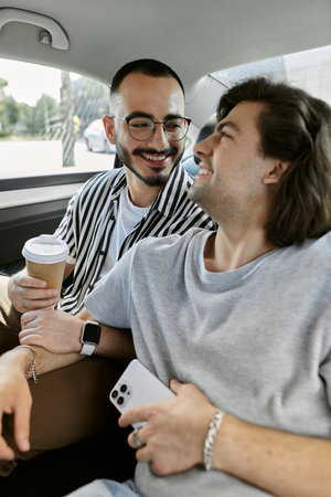 A gay couple shares a laugh while riding in a car.の写真素材