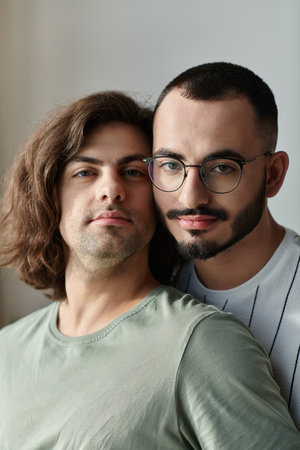 Two men share a tender moment, looking into each other's eyes.