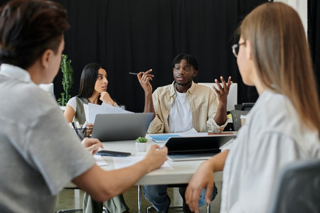 A group of professionals gather around a table in a modern office, discussing ideas and plans.の写真素材