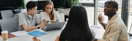 Four individuals collaborate around a table, engaged in a lively discussion.