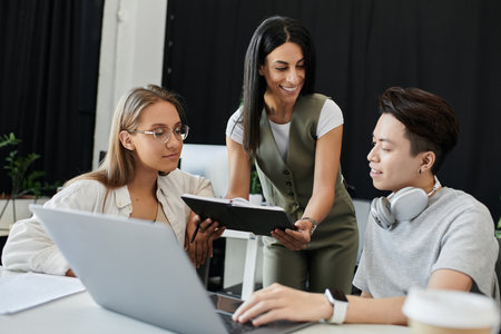 Three people work together on a project in a modern office.の写真素材