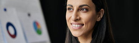 A woman with dark hair and a bright smile looks towards the future.