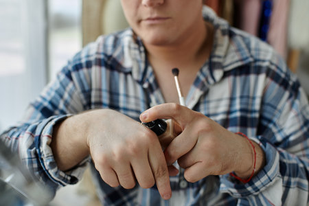 A queer person applies foundation to their hand before applying it to their face.の写真素材