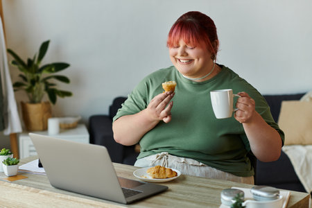 A plus-size woman enjoys a pastry and coffee while working from home.の写真素材