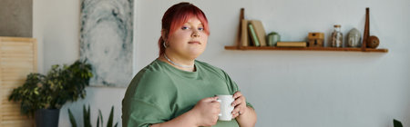A plus size woman with pink hair holds a mug in her living room.