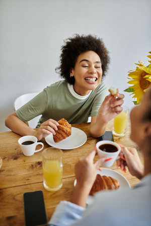 A happy couple shares breakfast, savoring croissants and warm drinks together.の写真素材