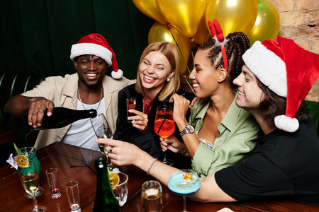 A group of young colleagues enjoy a festive celebration, sharing laughter and drinks together.の写真素材