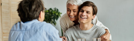 A loving LGBTQ family enjoys breakfast together, sharing smiles and laughterの写真素材