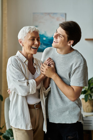 A middle-aged mother and her adult son share laughter and love in a cozy home setting.