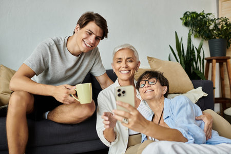 A loving family enjoys quality time together, sharing smiles and laughter while connecting through technology.の写真素材