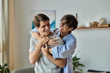 A middle-aged mother shares a warm embrace with her adult son in a bright and inviting living space.の写真素材