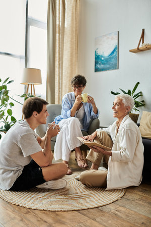 A loving LGBTQ family shares laughter and stories in their inviting living space, enjoying each others company.の写真素材