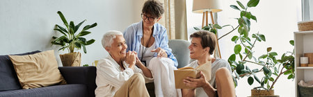 A loving LGBTQ family engages in joyful conversation, creating cherished memories in their cozy living room.の写真素材