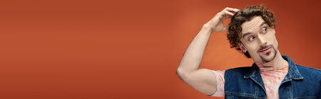 A charismatic man poses thoughtfully in front of a vivid backdrop.の写真素材