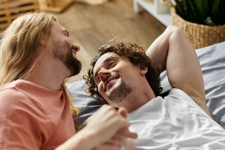 A loving couple shares a tender moment, smiling and holding hands indoors.の写真素材
