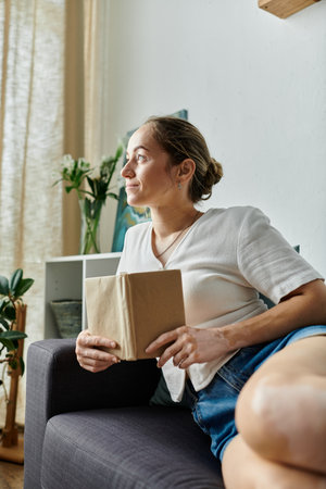 A woman with vitiligo enjoys a quiet moment while reading in soft, natural light.