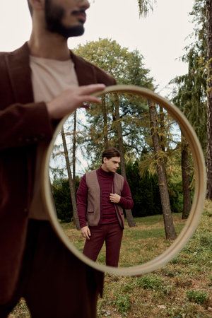 Two dapper men showcase autumn fashion in a picturesque field, embracing the season warm hues and...