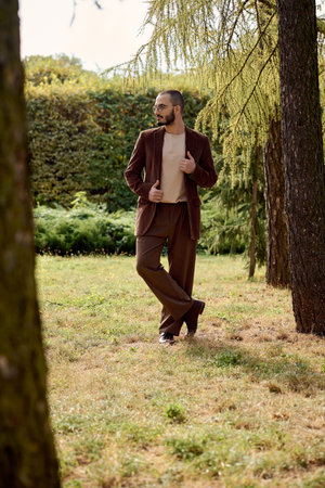 handsome man showcases autumn fashion while enjoying a tranquil outdoor experience in nature.の写真素材