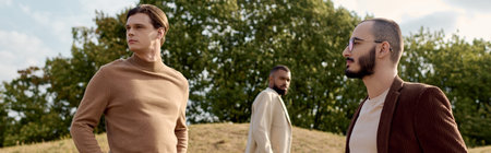 Three handsome men display their fashionable autumn outfits while enjoying the tranquility of a...