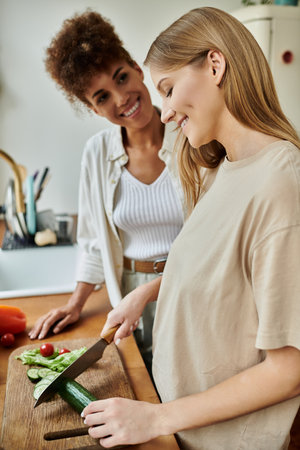 A loving couple prepares a fresh meal, sharing smiles and laughter in their cozy kitchen.の写真素材