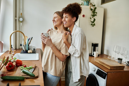 Two partners share a delightful moment while preparing meals in their warm kitchen.の写真素材