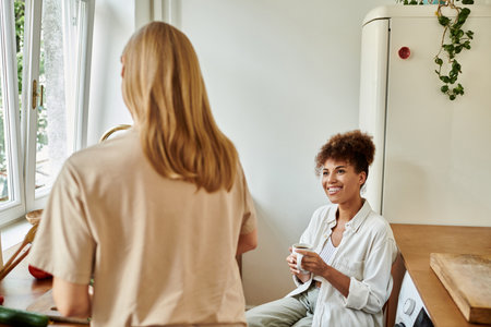 A cheerful couple enjoys a warm drink together in their stylish kitchen.の写真素材