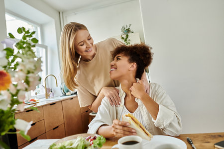 A happy couple shares a moment over breakfast in a charming kitchen.の写真素材